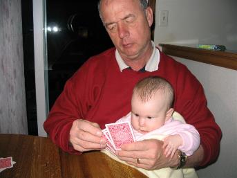Audrey sitting in Grandpa's lap, learning how to play Euchre at the same age her Daddy did. (So I've been told).