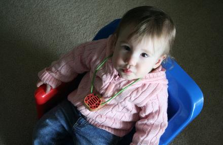 Audrey's ladybug necklace.  She likes to look at it in the mirror, and when she does, she always says cuuuute.  In her chair again, by the way...