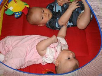 Audrey's trying to roll over.  On her back she will arch her back, reach her head back, and get on her side...  She just needs to swing her hips over and she'll get it.  Also in the picture is Liesl who has also grown up a lot.  She's six months old now.