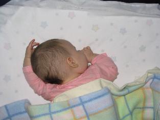 Audrey sleeping in an 'en garde' pose.  Laura thought it was really cute so she took the picture. Audrey's reaching over her head for all sorts of stuff now.  It's fun that she's discovered a new dimension.