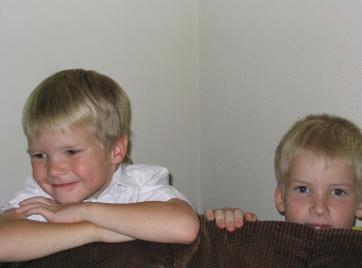 Hiding behind the couch.